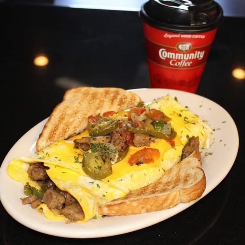 A Smiley's Grill omelet with meat, peppers, and cheese, served with toast and Community Coffee.